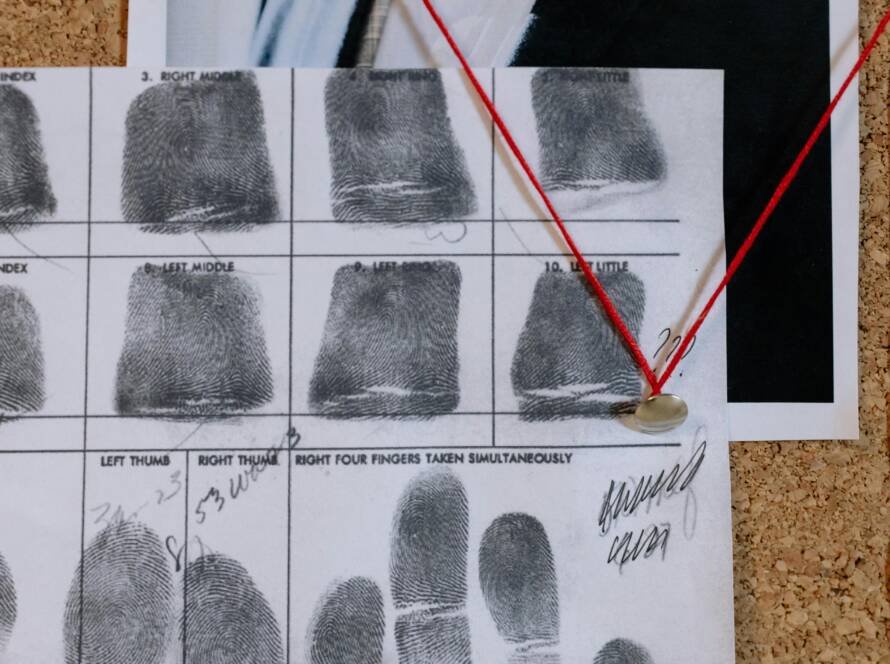 Detailed close-up of fingerprint card pinned on a corkboard, showcasing identity documentation.